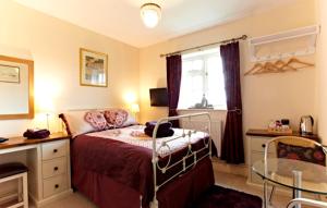 1 dormitorio con cama, escritorio y ventana en Wayside B&B en Norwich