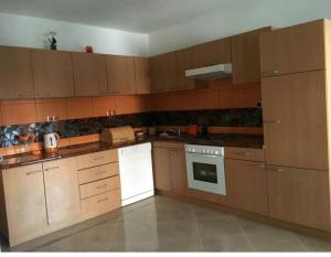 a kitchen with wooden cabinets and a white stove top oven at Adriatic Queen in Gdinj