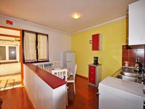 a kitchen with a sink and a table and a refrigerator at Apartments Paliska in Rabac