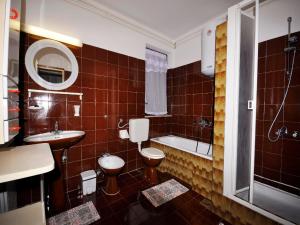 a bathroom with a toilet and a sink and a tub at Apartments Paliska in Rabac +45 photos