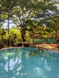 a large swimming pool in a yard with a tree at Chales Jack & Jill in Pipa