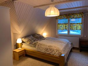 una camera da letto con un letto con due lampade e una finestra di Sosnowy Zakatek a Wisła
