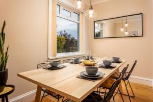 a dining room table with chairs and a large mirror at Sunset View - Donnini Apartments in Ayr