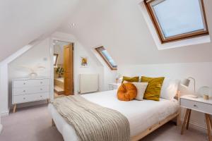 um quarto com uma cama branca com almofadas laranja em Sunset View - Donnini Apartments em Ayr