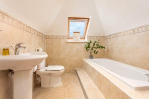 uma casa de banho com um WC com lavatório e uma banheira em Sunset View - Donnini Apartments em Ayr
