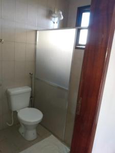 a small bathroom with a toilet and a window at Pousada Dos Girassois Prado in Prado +11 photos