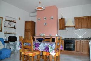 uma cozinha com mesa e cadeiras num quarto em Su Muscadeddu em Tertenìa