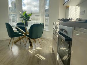 eine Küche mit einem Tisch und Stühlen im Zimmer in der Unterkunft Stylish Pontcanna Flat Near City Centre in Cardiff