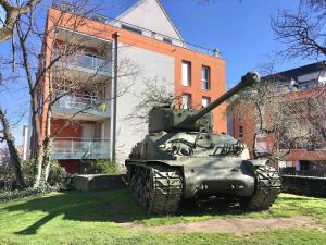 einem Panzer, der im Gras vor einem Gebäude sitzt in der Unterkunft Au Coeur de Colmar in Colmar