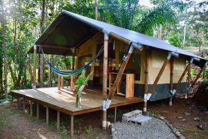 a small shack with a hammock in the woods at El Pulpo Safari Lodge in Ojochal