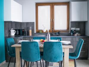 a kitchen with a wooden table with blue chairs at OSADA Rokicie in Kluszkowce