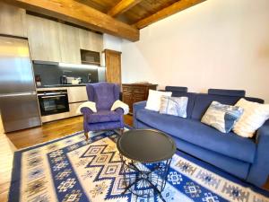 a living room with a blue couch and a table at Rustic Chic de Luxe 47E in El Tarter