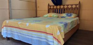 a bed with a striped blanket and pillows on it at Centro Ecoturistico Ya´ajche in Lacanjá