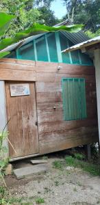 a wooden door with a green window on a building at Centro Ecoturistico Ya´ajche in Lacanjá