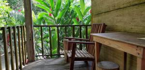 a porch with a table and a chair on a balcony at Centro Ecoturistico Ya´ajche in Lacanjá