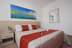 a bedroom with a large bed with red and white pillows at Residence Il Cardellino in San Vincenzo