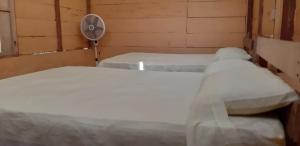a small room with two beds and a fan at Centro Ecoturistico Ya´ajche in Lacanjá