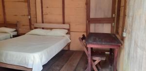a small room with a bed and a table at Centro Ecoturistico Ya´ajche in Lacanjá