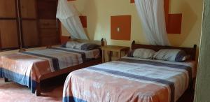 a bedroom with two beds and a table at Centro Ecoturistico Ya´ajche in Lacanjá