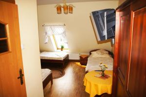 ピシュにあるPensjonat u Marysiのベッド2台とテーブルが備わる小さな客室です。