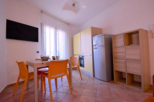 a kitchen with a table and chairs and a refrigerator at Residence Il Cardellino in San Vincenzo