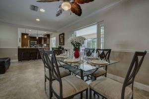 a dining room with a glass table and chairs at Avenida Sanctuary in Siesta Key