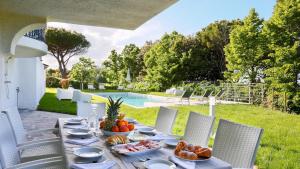 einen Tisch mit Speisen auf einer Terrasse mit Pool in der Unterkunft Villa Sarah 102 Emma Villas in Riccione