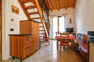 una cucina con scala e una sala da pranzo con tavolo di 2 bedrooms apartement with furnished balcony at Riolunato 4 km away from the slopes a Riolunato