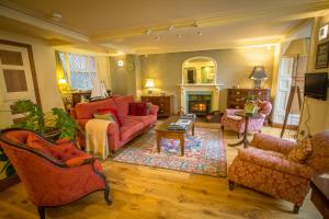 uma sala de estar com mobiliário vermelho e uma lareira em The Drovers Bed and Breakfast em Llandovery