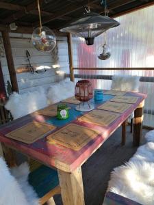 uma mesa de madeira num quarto com penas brancas em le gite de zoelie em Chaineux