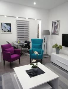 ein Wohnzimmer mit blauen und violetten Stühlen und einem Tisch in der Unterkunft Apartman DIN in Travnik