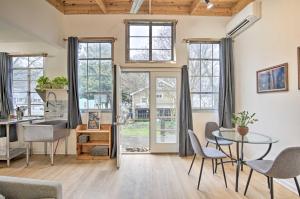 - un salon avec une table, des chaises et des fenêtres dans l'établissement Cozy Artists Cottage 3 Mi to Lookout Mtn!, à Chattanooga