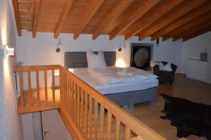una camera da letto con un letto con lenzuola bianche e un soffitto in legno di Prinz City Apartments a Neckarsulm