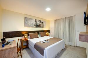 モロ・デ・サンパウロにあるポサーダバヒアバカナの大きなベッドとデスクが備わるホテルルームです。