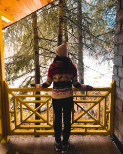 a woman is standing on a wooden bridge at The Hosteller Manali in Manāli