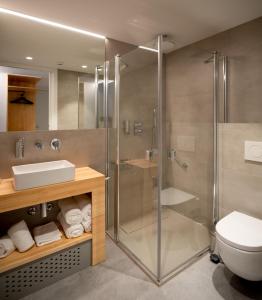 Un baño con ducha de cristal y un inodoro. en Cristina Enea Rooms, en San Sebastián