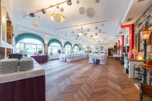 a dining room with white tables and white chairs at Bergschlößchen in Jüterbog