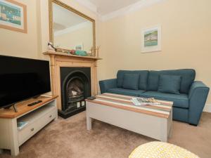 a living room with a blue couch and a fireplace at 5 Fairview Road in Dartmouth