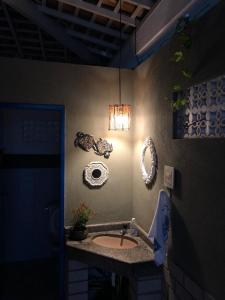 baño con lavabo y una luz en la pared en Casa na praia do saco - Casa Jardim praia do saco, en Praia do Saco