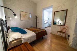 ein Schlafzimmer mit einem Bett, einem Spiegel und einem Stuhl in der Unterkunft Eco-Aparment Vegueta in Las Palmas de Gran Canaria