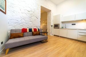 ein Wohnzimmer mit Couch und Küche in der Unterkunft Eco-Aparment Vegueta in Las Palmas de Gran Canaria + 9 Fotos
