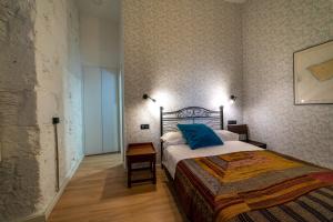 ein Schlafzimmer mit einem Bett mit blauen Kissen darauf in der Unterkunft Eco-Aparment Vegueta in Las Palmas de Gran Canaria