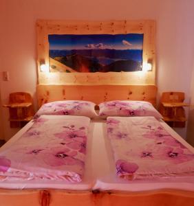 a bedroom with a bed with pink sheets and a window at Sonnhof in Sankt Gilgen