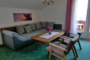 a living room with a couch and a table with flowers on it at Sonnhof in Sankt Gilgen