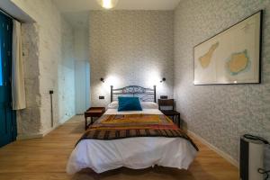 ein Schlafzimmer mit einem Bett und einem Bild an der Wand in der Unterkunft Eco-Aparment Vegueta in Las Palmas de Gran Canaria