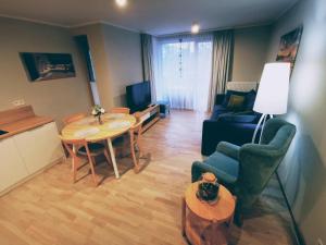 een woonkamer met een tafel en stoelen en een keuken bij Apartament w Rezydencji Park in Mielno