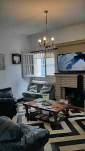 sala de estar con mesa de centro y TV en Blau Hostel en Villa Carlos Paz