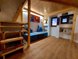 a living room with a blue couch in a tiny house at Guest House Piazza Marconi in Amelia