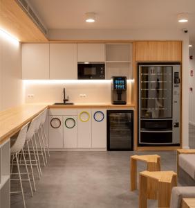 Una cocina con gabinetes blancos y electrodomésticos negros. en Cristina Enea Rooms, en San Sebastián