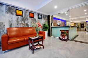sala de estar con sofá de cuero y chimenea en Golden Lotus Hotel, en Nha Trang